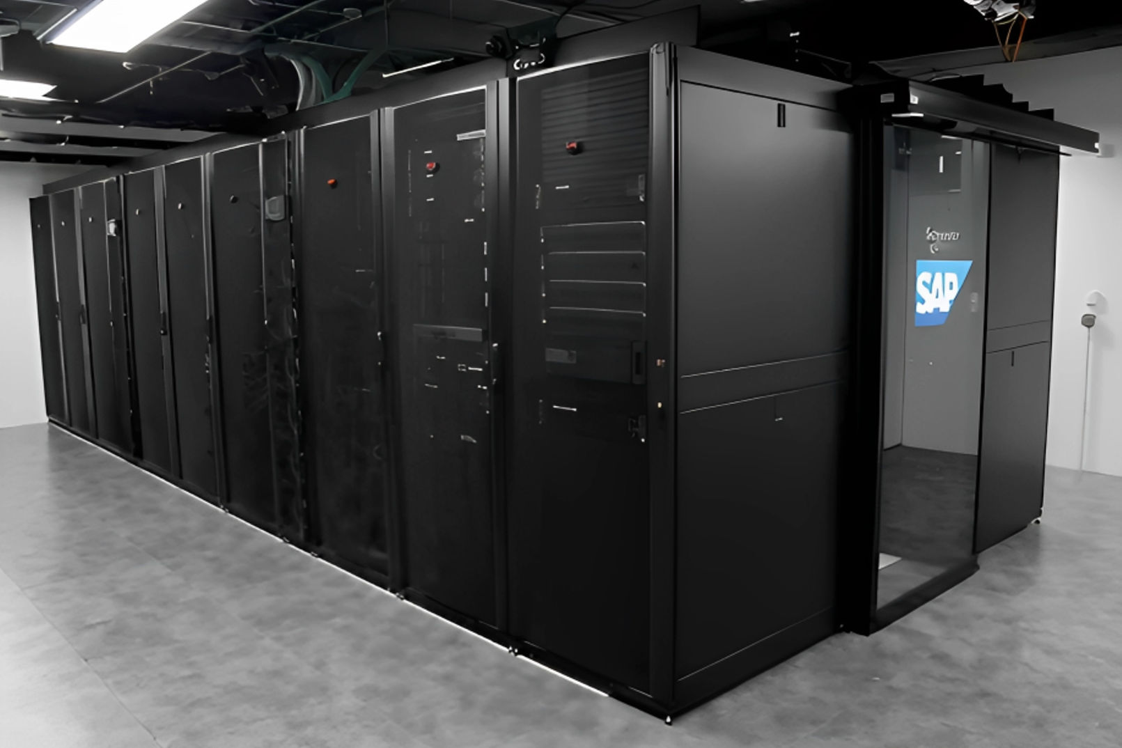 A large room featuring black servers and a door, indicating a tech or data center environment.