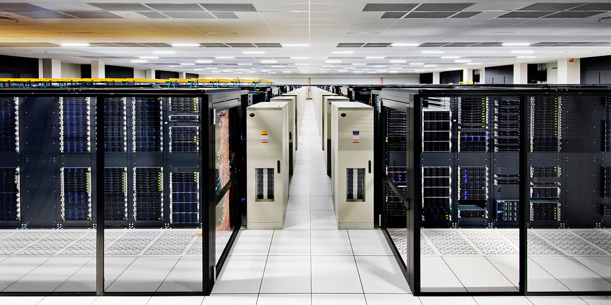 A spacious room filled with multiple rows of servers, showcasing a high-tech data center environment.
